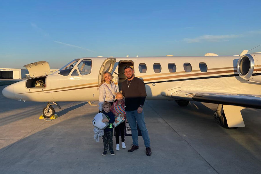 Family in front of small private jet